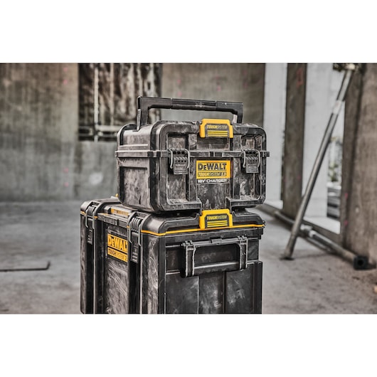 Stacked DEWALT ToughSystem toolboxes in a rugged, industrial setting, showing durability and storage capacity.