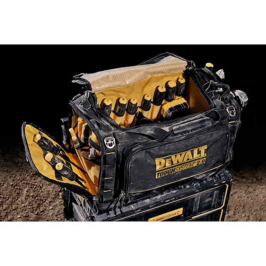 DEWALT ToughSystem 2.0 tool bag shown open, filled with hand tools and accessories on a stack of cases.