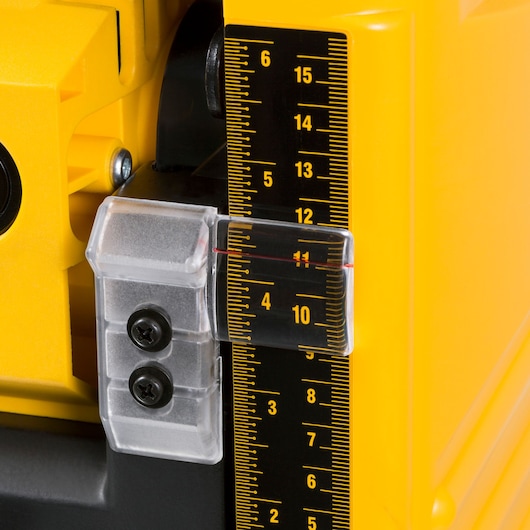 Close-up of a yellow DEWALT machine with a precise black and yellow ruler and adjustable indicator.