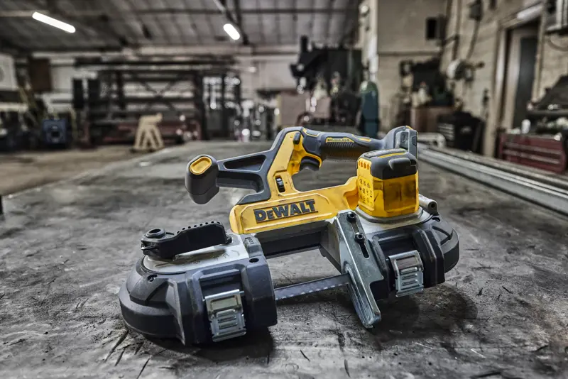 Scie à ruban sans fil DEWALT sur un établi en métal dans un atelier.