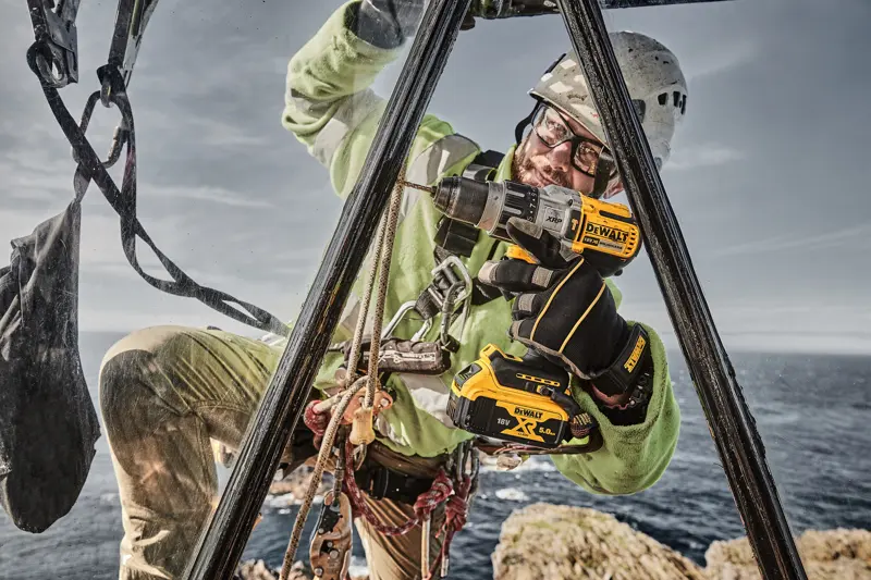 DEWALT DCD996P2, DCD996P2-QW perceuse utilisée dehors par ouvrier, mer et rochers. Catégorie photographie.